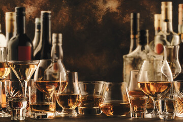 Hard strong alcoholic drinks and distillates in glasses and bottles in assortment: vodka, cognac,...
