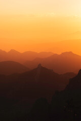 Stunning misty sunset over mountain silhouette horizon