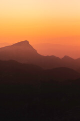 Stunning misty sunset over mountain silhouette horizon