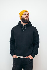 Portrait of handsome bearded hipster guy wearing black blank hoodie with space for your logo or...