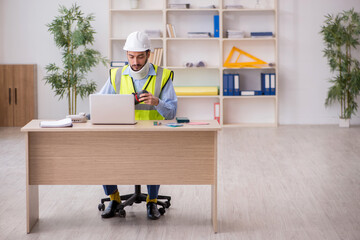 Young neck injured male architect in safety concept