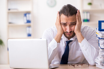 Young businessman unhappy with excessive work in the office