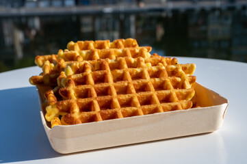 Sweet fresh baked Belgian waffles served outdoor with view on Maas river in Dinant, Wallonia, Belgium.
