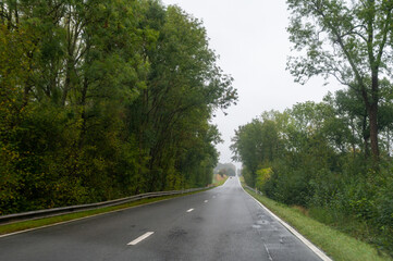 Fototapeta na wymiar Driving on asphalt road in cloudy rainy day