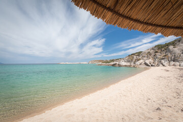Exotic sandy beach with clear blue water and umbrella