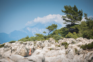Mediterranean rocky beach landscape with mountain Athos in background