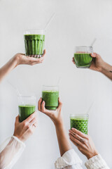 Glasses of detox healthy green smoothie in hands - 420334976