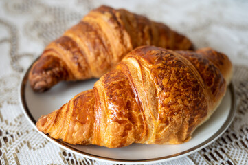 Two fresh baked puff croissants, traditional French breakfast