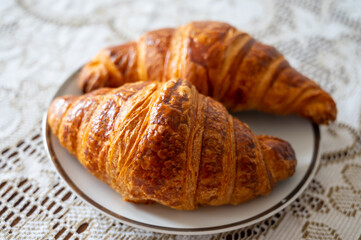 Two fresh baked puff croissants, traditional French breakfast