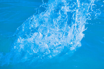 Splashes and drops of blue sea water close-up background. Focus on the water