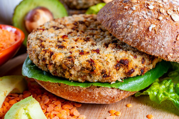 Tasty vegetarian healthy food, homemade burgers made from orange lentils legumes with green lettuce and fresh ripe avocado