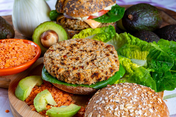 Tasty vegetarian healthy food, homemade burgers made from orange lentils legumes with green lettuce and fresh ripe avocado