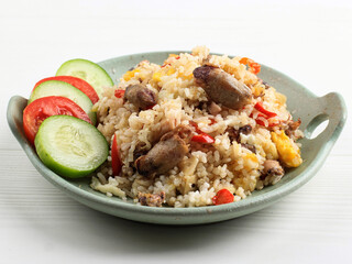 Nasi Goreng Cumi Asin (Fried Rice with Salted Squid), Cooked with Chilli, Spicy and Delicious. Typical Indonesian Homemade Food. Served on Green Plate, isolated on White Background