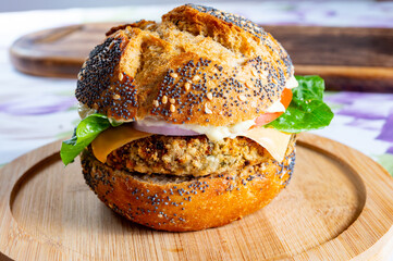 Tasty vegetarian food, homemade burgers made from orange lentils legumes with onion, green lettuce and tomatoes