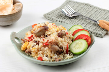 Nasi Goreng Cumi Asin (Fried Rice with Salted Squid), Cooked with Chilli, Spicy and Delicious. Typical Indonesian Homemade Food. Served on Green Plate, isolated on White Background