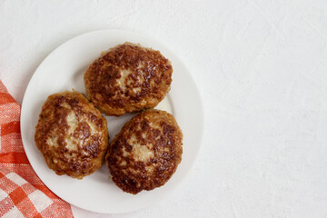 Homemade cutlets on a plate isolated on a white background.