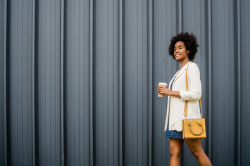 Portrait of afro business woman walking outdoors.