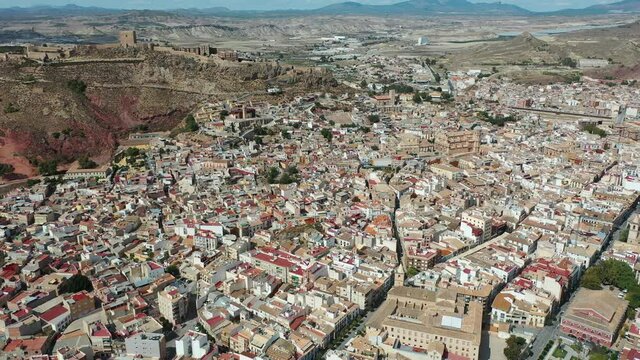 Aerial view of Spanish city of Lorca overlooking Collegiate church of St. Patrick and ancient castle on hilltop on sunny autumn day. High quality 4k footage