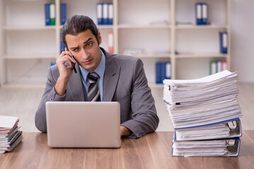 Young male employee unhappy with excessive work in the office