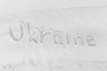 The word Ukrainian sign or symbol written on white beach sand close-up