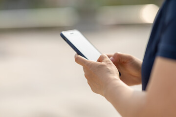 Asian woman using smartphone outdoors