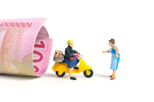 Miniature people toys conceptual photography. COD (Cash on delivery) service. Postman courier with cash money paper, isolated white background.