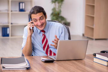 Fototapeta premium Young male employee sitting at workplace