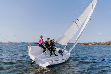 Dad and his two daughters went out on a yacht on the river to sail along the city, and teach the...