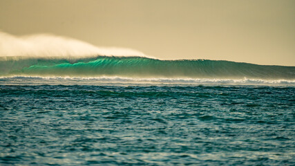 Huge barrel green wave at sunset. Indian ocean waves breaking onto the reef in Mauritius.