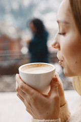 Women with a cup of coffee. Wonderful holiday in mountains. Snowy weather.