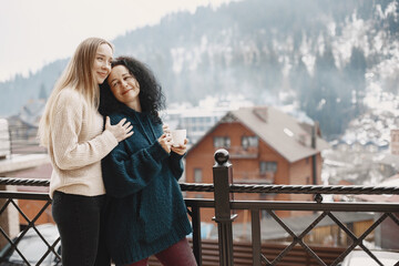 Women with a cup of coffee. Wonderful holiday in mountains. Snowy weather.