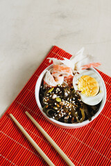 home cooking seaweed salad, crab, egg, sesame and pumpkin seeds on red Asian napkin and chopsticks. veganism in food. simple asian recipes at home. seaweed dishes.selective focus