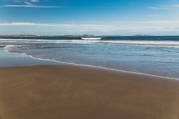  Kingston beach in southern Hobart in Tasmania, Australia on a sunny windy day with intense swell and waves and no people