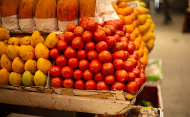 jitomates en super mercado junto a mangos