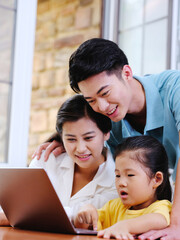 Happy family of three using laptop