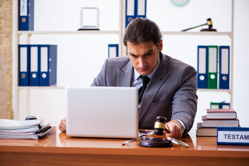 Naklejka premium Young male lawyer sitting in the office