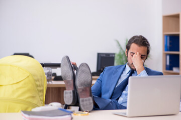 Young male employee looking after new born at workplace