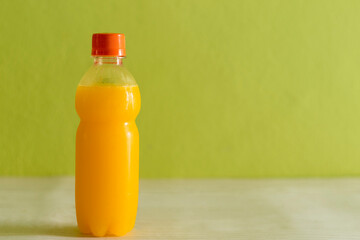 Orange juice in the bottle isolated background wall
