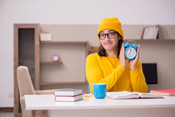 Young male student preparing for exams at home