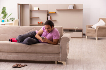 Young man watching tv at home during pandemic