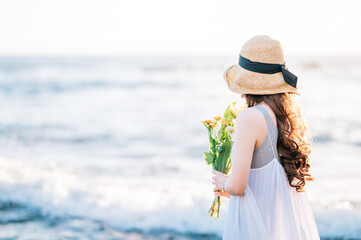海で花を持つ女性