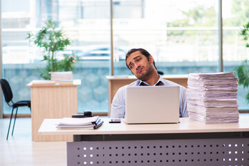 Young male employee unhappy with excessive work in the office