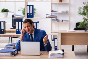 Young handsome employee sitting in the office