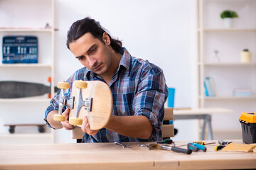 Young man repairing skateboard at workshop