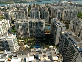 Fototapeta premium Aerial view of Jacarépaguá, Rio de Janeiro neighborhood on a sunny day. Buildings, mountains, nature and blue sky in this drone photo