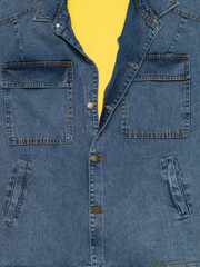 Partially buttoned denim jacket on a yellow background.