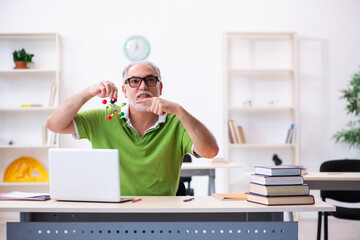 Old male student physicist studying molecular model