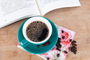 A cup of coffee in front of the open book