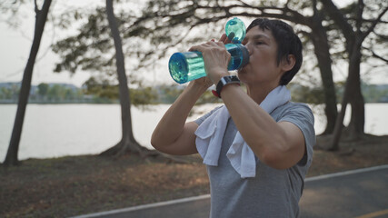 thirsty senior asian woman drinking fresh water at park