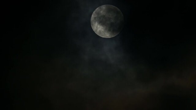 Moon descending covered by thick clouds giving a strange and horror look, the length of the video good for narrating and adding graphics around.